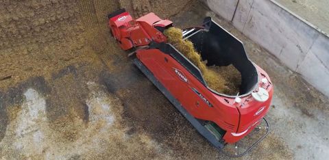 L’ensemble fraise-convoyeur s’est ici translaté latéralement sur la largeur de la machine pour assurer le désilage sans déplacement de la mélangeuse. © Kuhn