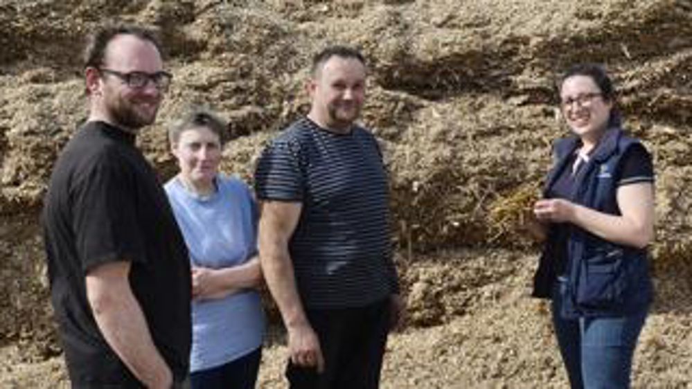 Patrice, Évelyne et Gérard Soete, devant le silo de maïs avec Agathe Vandaele, conseillère à Avenir Conseil Élevage.
