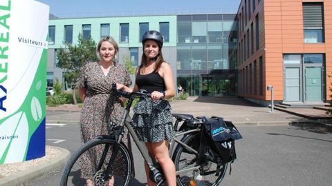 Fanny Amé (à g.), responsable moyens généraux et mobilités du groupe Axéréal, pose ici avec sa collaboratrice Athénaïs Andréo, en charge de la gestion du parc de véhicules, qui teste pour un mois un vélo à assistance électrique.