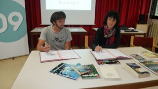 Evan Dreux signe la convention de don de livres avec la présidente du Conseil départemental de l’Ariège, Christine Téqui.