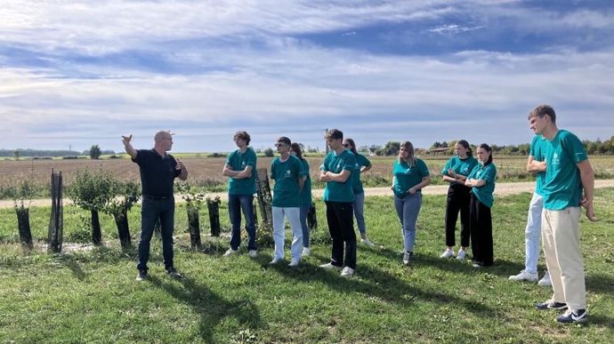Hervé Martin, responsable agronomique et filières d'Alliance BFC, fait visiter une de leur plateforme nouvelles cultures à un groupe d'alternants de Dijon céréales.