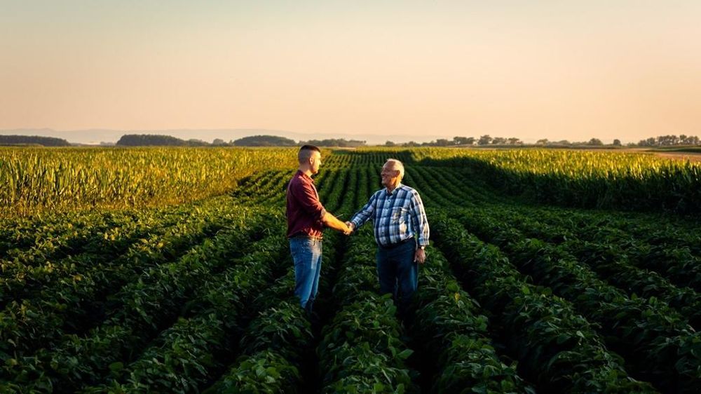 Deux agriculteurs se serrant la main dans un champ