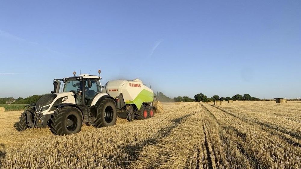Presse à balles carrées au champ