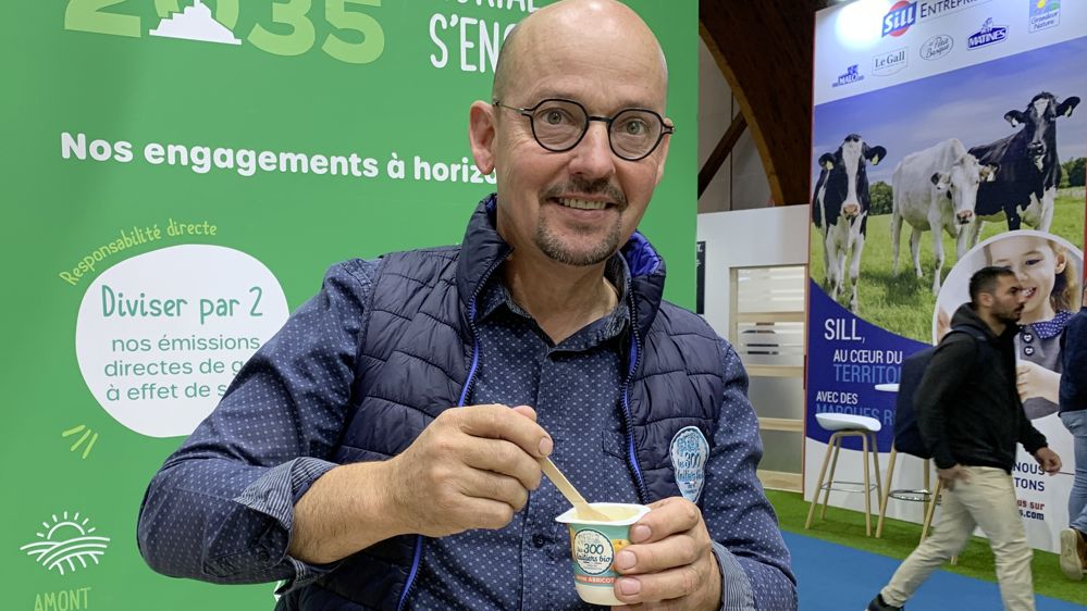 Un éleveur laitier présente un yaourt bio