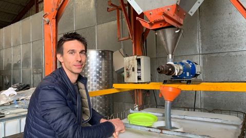 Florian Ballot devant sa presse à huile de colza et tournesol
