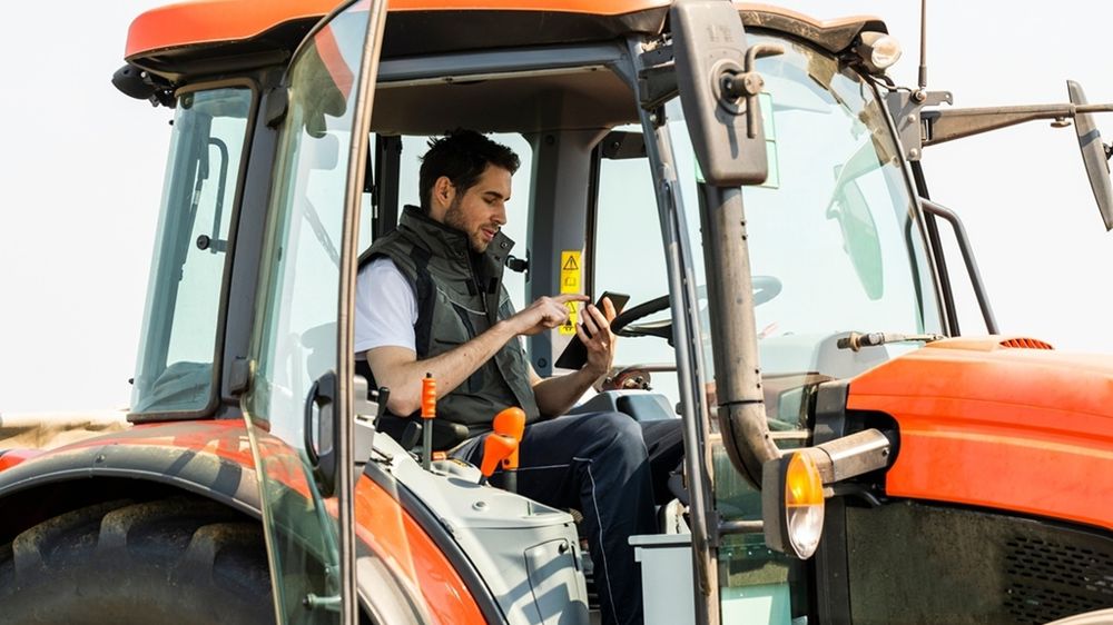 Agriculteur dans un tracteur avec une tablette