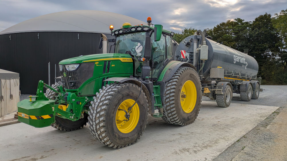 Le John Deere 6R 250 chausse les RoadBib pour effectuer le transport du digestat avec une tonne routière.