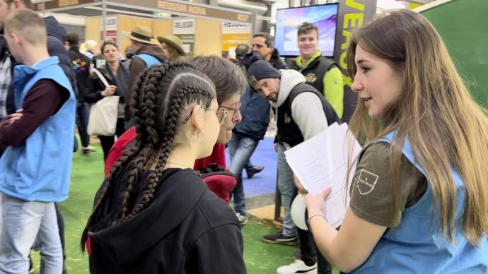 Deux visiteuses tentent de remporter  un autre jeu proposé par les apprentis : un rébus, photos à l'appui.