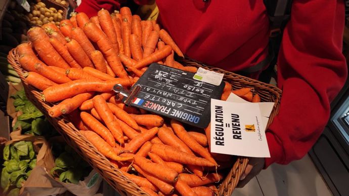 Une agricultrice récupère des carottes en vrac mentionnées « origine France » dont la provenance est écrite « Italie ».